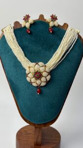 Necklace displayed on wooden stand.